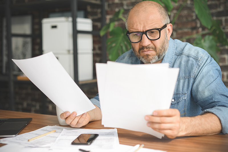 man with glasses looking at paperwork
