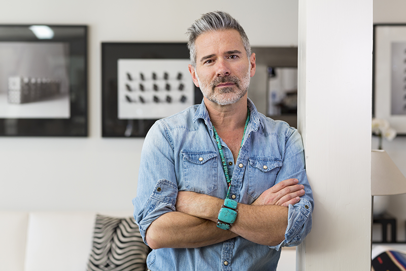 man leaning against wall with arms crossed