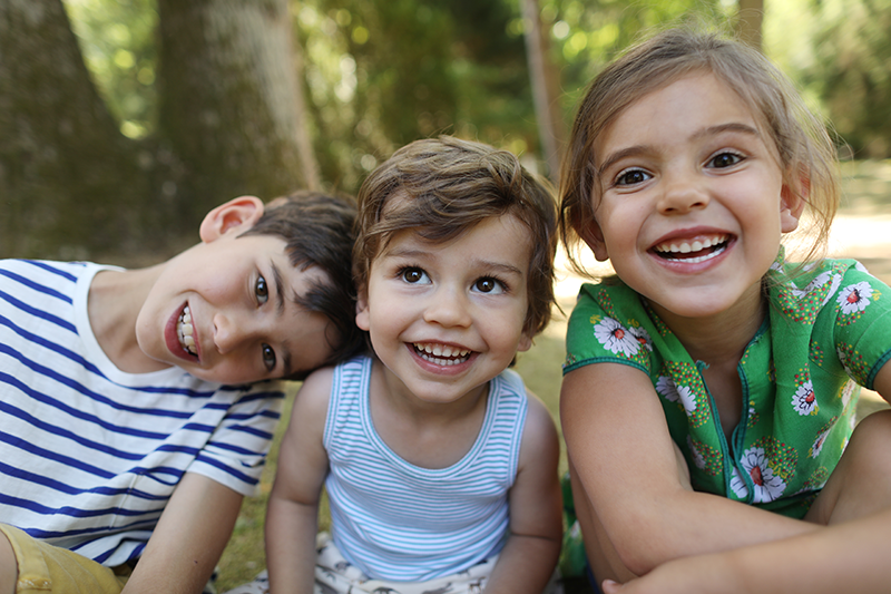 three kids outside smiling