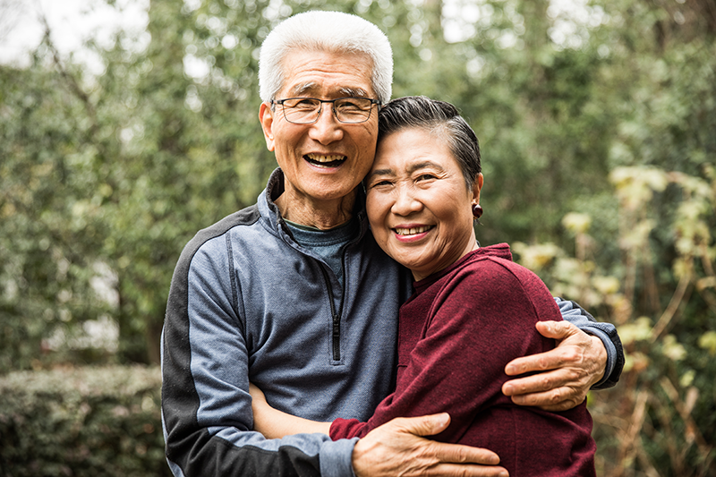 older couple hugging smiling and looking at camera