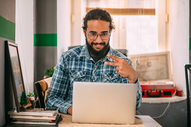 man sitting at computer doing sign language