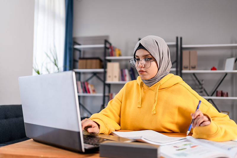 woman sitting at computer taking notes