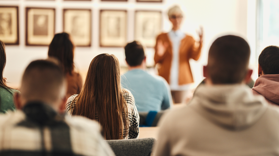 Adults in a classroom listening to teacher